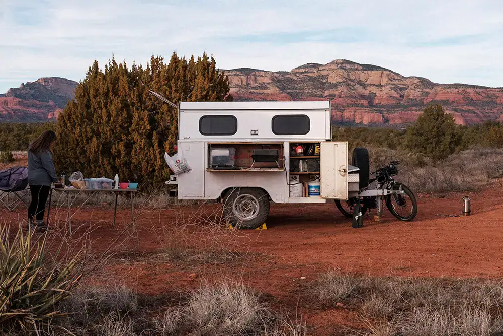 Four Wheel Camper set up for boondocking with bike, off-grid overlanding in desert landscape.