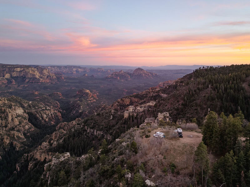 Four Wheel Camper rigs boondocking off-grid at scenic overlanding overlook during sunset.