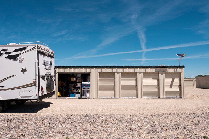 Four Wheel Camper parked by storage units with solar panel, Boondocking, Off-grid, Overlanding setup.