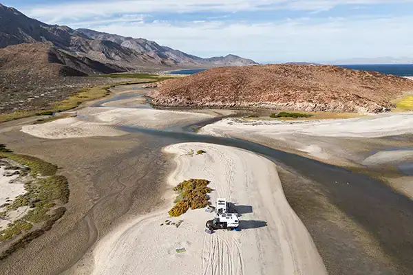 Two Four Wheel Campers parked for off-grid boondocking overlanding, Baja desert landscape.