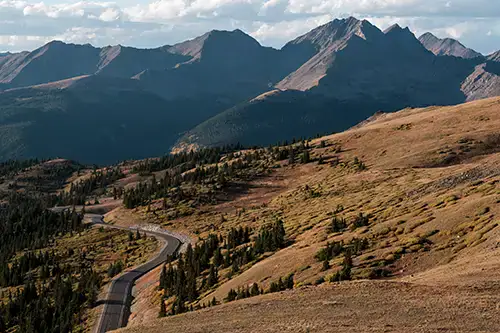 Mountain road winds through alpine terrain, ideal for overlanding, boondocking, off-grid adventures.