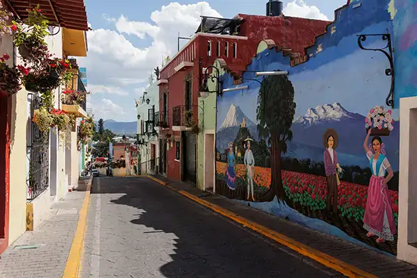 Colorful mural street scene with people and mountains, perfect for off-grid overlanding adventures.
