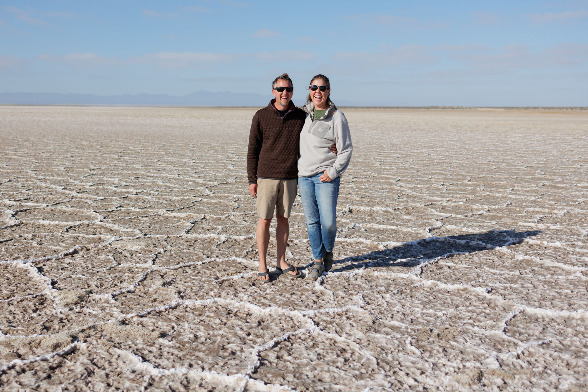 Couple enjoys boondocking off-grid overlanding on vast salt flats.